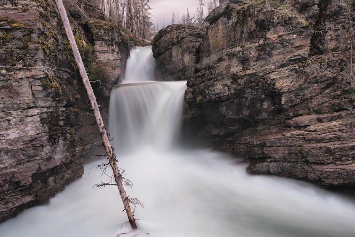 Long exposure photograph of a waterfall cascading through rocky canyon with silky smooth water effect