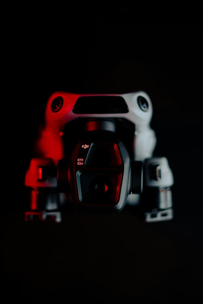 DJI Air 3S drone close-up with dramatic dark lighting highlighting its sleek modern design and camera system