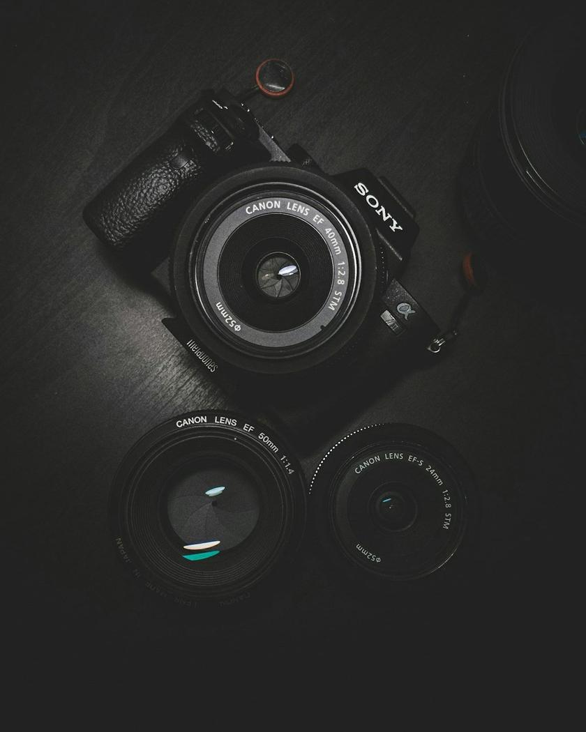 Collection of professional camera lenses arranged on a table showing various focal lengths for landscape photography
