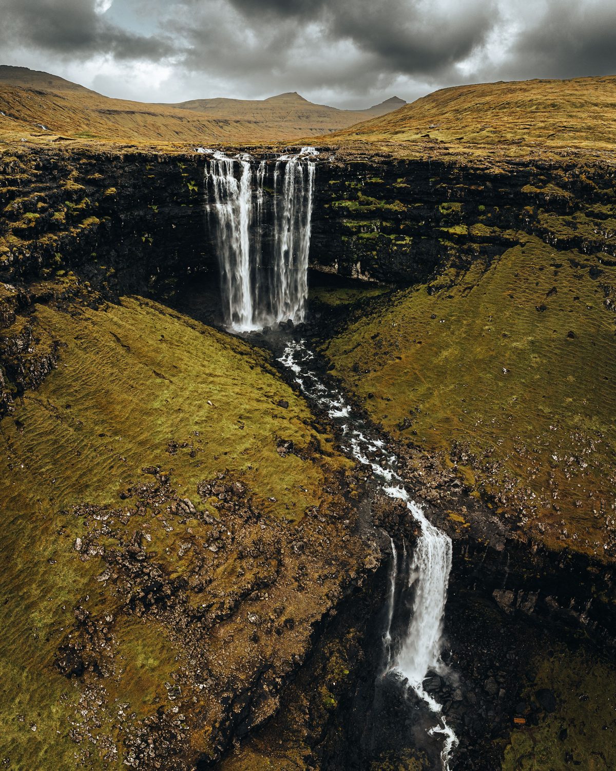 Dramatic Faroese waterfall cascading down moss-covered cliffs